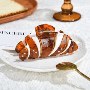 Pinza para pelo croissant en resina ámbar con pedrería en estética cálida de café