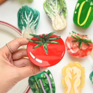 Macro shot of tomato shaped acetate hair claw clip with glossy finish and vibrant red color