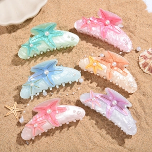 Starfish hair claws with pearls in six pastel colors on a sunny beach background