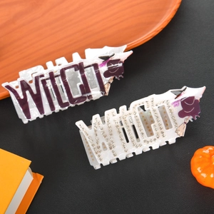 Detailed close-up of Halloween witch theme hair claw clips with purple rhinestones