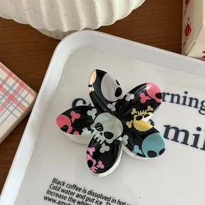 Gros plan d'une pince à cheveux fleurie style punk avec motifs têtes de mort colorés