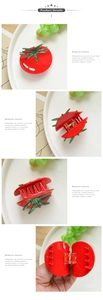 Detailed views of red tomato-shaped acetate hair claw clip with green leaf accents