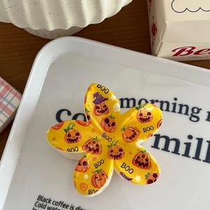 Détail de la pince à cheveux fleur jaune avec motifs de citrouille d'Halloween