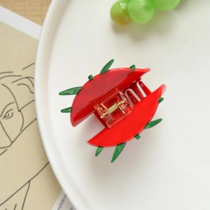 Detail of creative watermelon-shaped acetate hair claw clip with green serrated edges