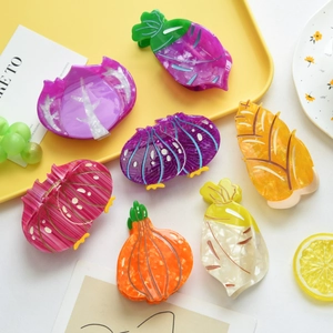 Pinces à cheveux uniques en acétate en forme de légumes comme l'oignon et le chou sur un plateau