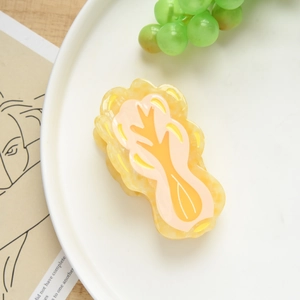 Detail showing the cabbage shaped hair claw clip made of textured acetate resin