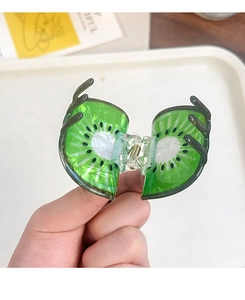 Détail d'une pince à cheveux créative en forme de kiwi avec graines et texture résine