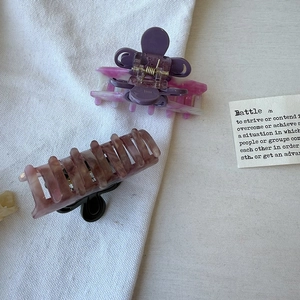 Détail de pinces à cheveux en acétate avec motifs de marbre violet et d'ambre translucide