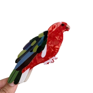 Pince à cheveux en forme de perroquet en acétate rouge avec des détails colorés