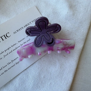 Détail d'une grande pince à cheveux fleur en acétate avec pétales violets et marbrures