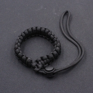 Detail of black paracord camera wrist strap with adjustable plastic buckle for outdoor gear
