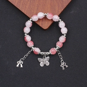 Perlenarmband mit rosa Farbverlauf, Schmetterlingsanhänger und floralen Akzenten