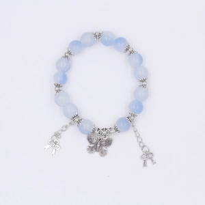 Detail eines Perlenarmbandes mit hellblauen durchscheinenden Perlen und geschnitztem Schmetterling