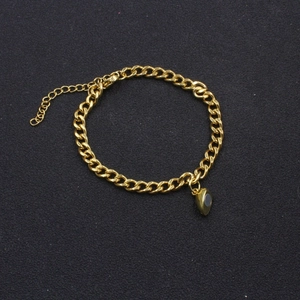 Golden Cuban chain bracelet with heart pendant on a minimalist black background