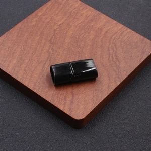 Cierre magnético de acero inoxidable negro pulido para pulseras de cuero en base madera