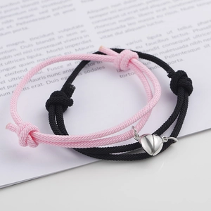 Magnetic couple bracelets set with heart-shaped charms and adjustable woven ropes