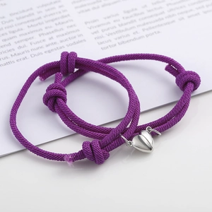 Macro detail of purple braided couple bracelets with heart shaped magnetic clasp
