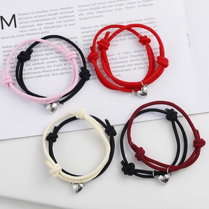 Detail of four pairs of heart magnet woven bracelets in various colors on a magazine background