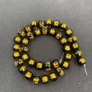 Macro shot of dark beads with golden Five Wealth Gods characters for DIY jewelry