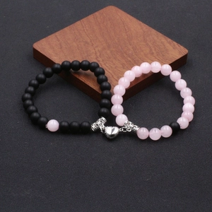 Gros plan de bracelets de couple cœur magnétique de 8mm avec perles noires et roses
