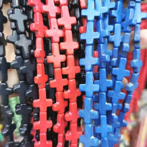 Close-up of multicolored cross-shaped beads in black, red, and blue for jewelry making
