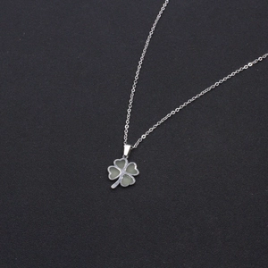 Elegant luminous four-leaf clover pendant necklace with silver chain on black background