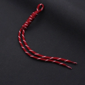 Macro detail of wine red woven nylon lanyard with white patterns and plastic end caps