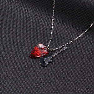Détail du médiator rouge marbré et pendentif guitare noire sur chaîne à billes argentée