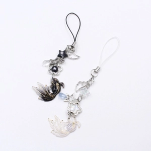 Detailed view of handmade koi fish pendants with star charms in black gold and pearlescent white