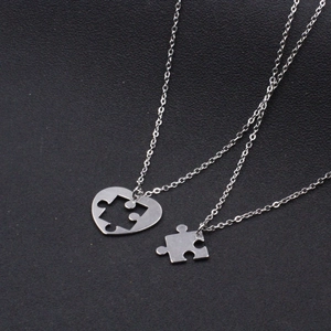 Kreative Herz-Puzzle-Halsketten aus Edelstahl für Paare auf schwarzem Hintergrund