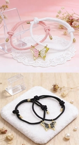 Detalle de pulseras magnéticas tejidas de mariposa con colgantes de esmalte y puntas de oro