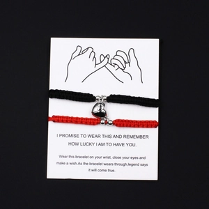Detail of magnetic heart charms on braided couples bracelets with message display card