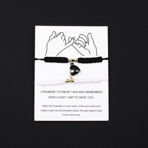 Handwoven heart magnet couple bracelets in black and white on elegant display card