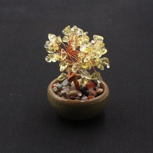 Detailed close-up of yellow crystal money tree with copper wire on a ceramic base
