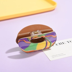 Macro detail of abstract colorful stripe pattern and sturdy metal spring on hair claw clip