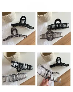 Detail showing marble grey and black ribbon hair claws with secure grip structure