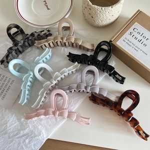 French style bow-shaped jelly hair claws in multiple colors on a textured white background