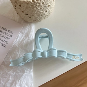 Macro view of light blue bow hair claw clip with gold Barrette LaFrance text detail
