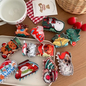 Diverses pinces à cheveux de Noël mignonnes avec Père Noël et renne sur une surface en bois
