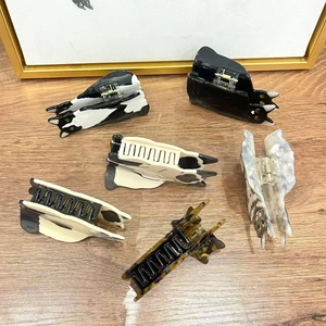 Detail of diverse cat-shaped acetate hair claws showing marble patterns and texture