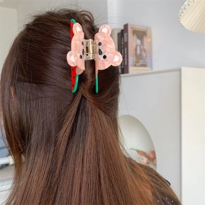 Detail of pink bear and watermelon acetate hair claw clip worn on hair in lifestyle setting