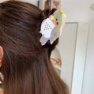 Detailed view of creative bird shaped acetate hair claw clip on brunette hair