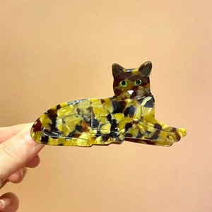 Detail view of a cat-shaped acetate hair claw clip with tortoise shell marble patterns
