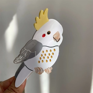 Cockatiel bird acetate hair claw clip with yellow crest and gray wing details in hand
