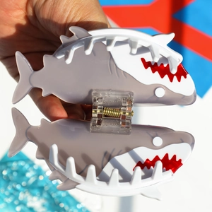 Detailed view of shark-shaped hair claw clip showing internal spring and opening mechanism
