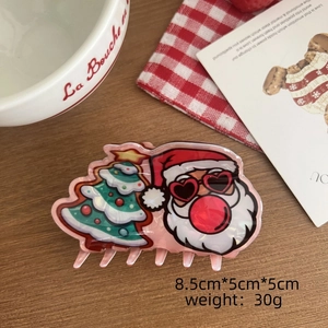 Détail d'une pince à cheveux de Noël avec Père Noël et sapin, mesurant 8,5cm x 5cm