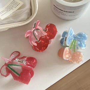 Three pieces of cute cherry claw clips in red, pink, and blue acrylic for women hair styling