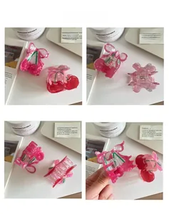 Detail shot of cherry hair claw clips in red and pink resin with green leaf accents