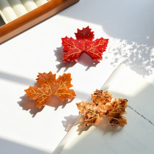 Detailed view of maple leaf hair claws in red, orange and tortoiseshell with rhinestones