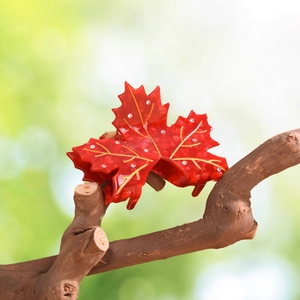 Close-up of red maple leaf hair claw clip with gold veins and white rhinestones